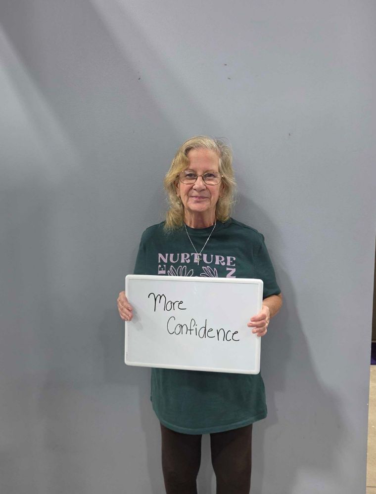 Ageless Fitness member holding a whiteboard sharing what they’re getting stronger for